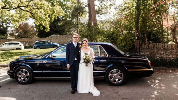 Newly-wed couple, Hattie and James, with the Bentley Arnage wedding car